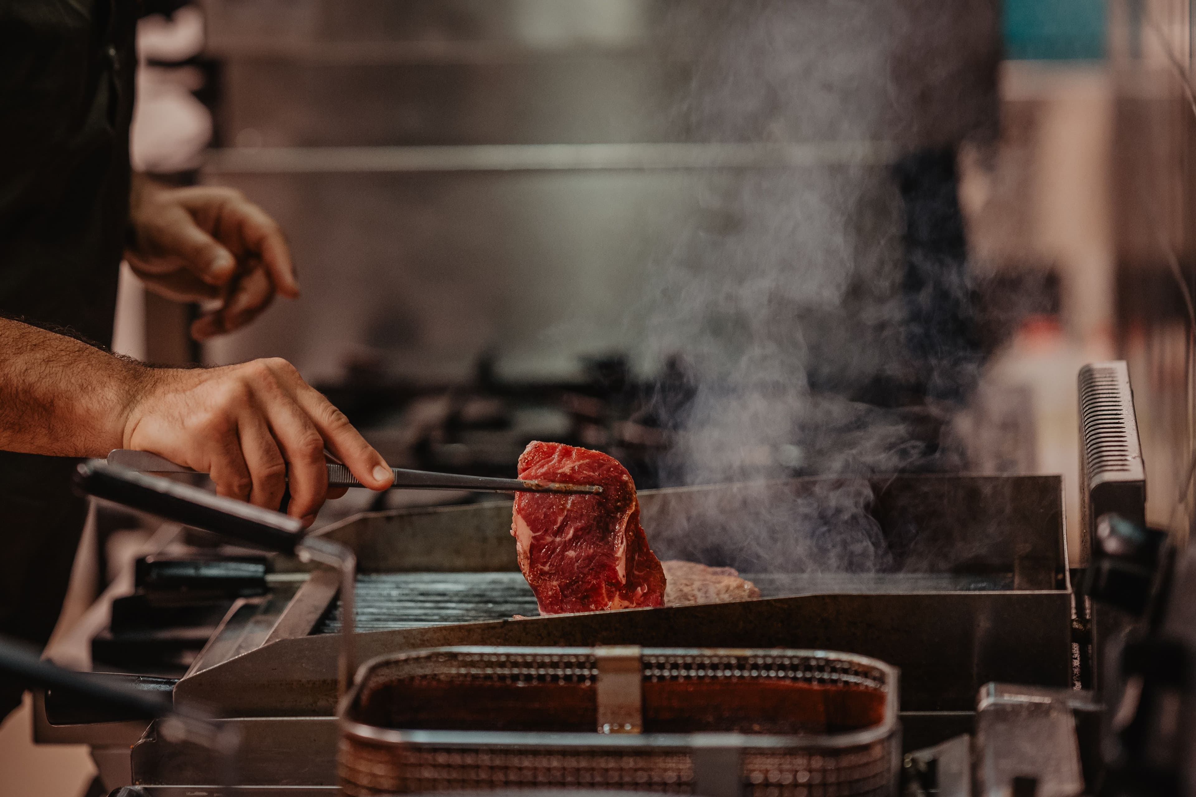Chef bereidt een gegrild stuk vlees in de keuken van Thermen Binnenmaas