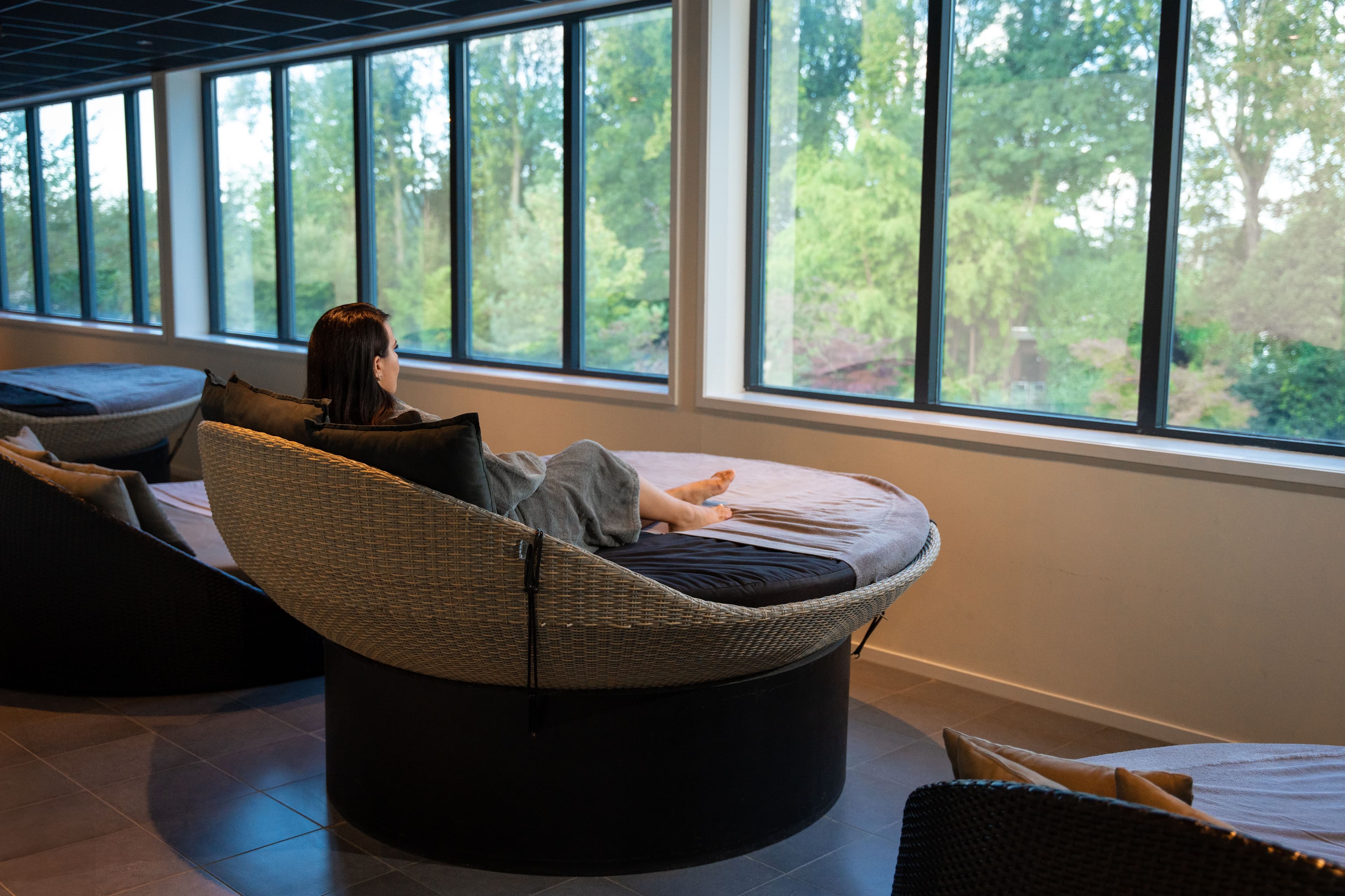 Ontspanningsruimte met uitzicht op de natuur en comfortabele stoelen bij Thermen Binnenmaas.