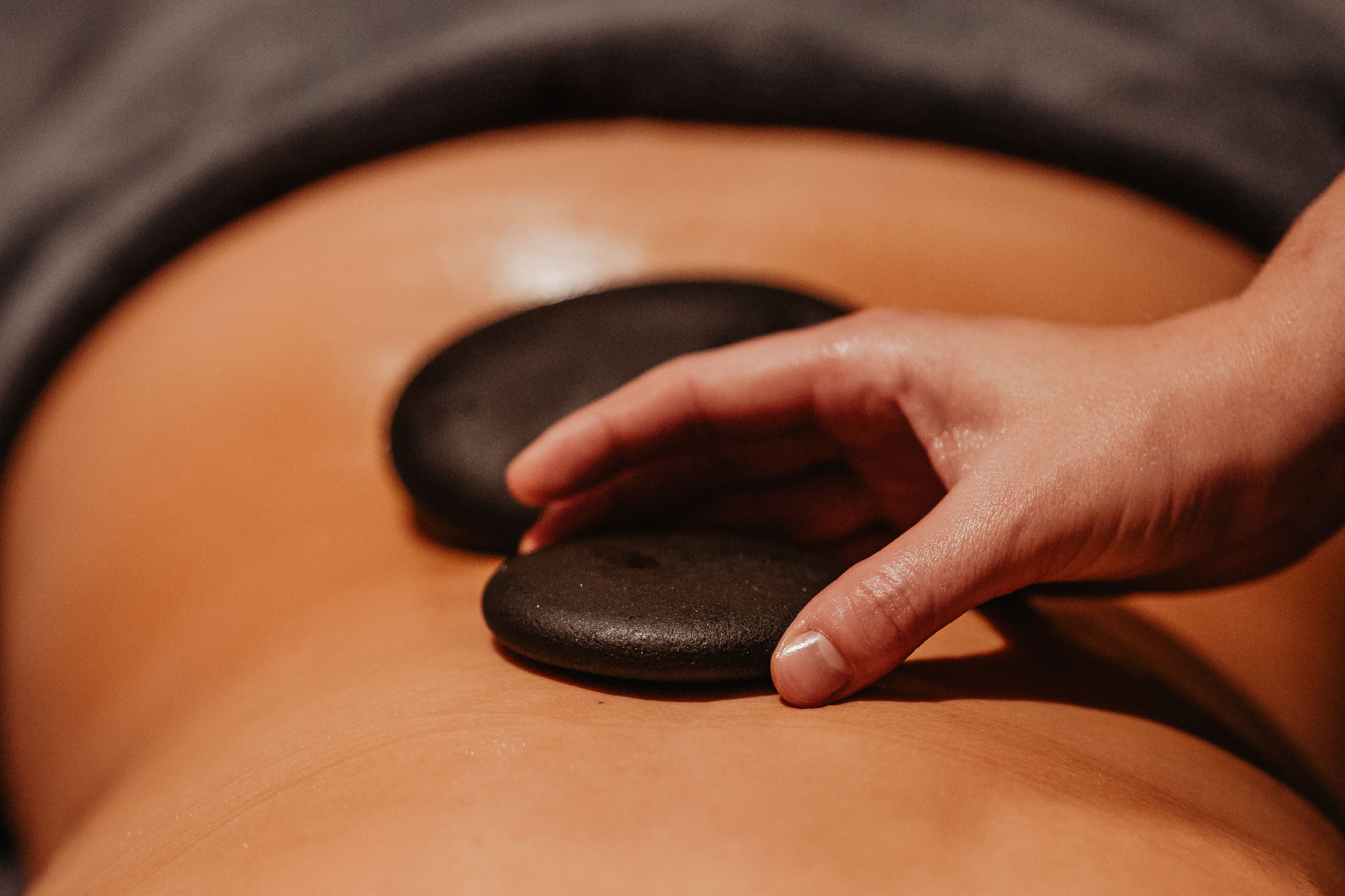 Hot stone massage op de onderrug voor diepe ontspanning en verlichting van spanning.