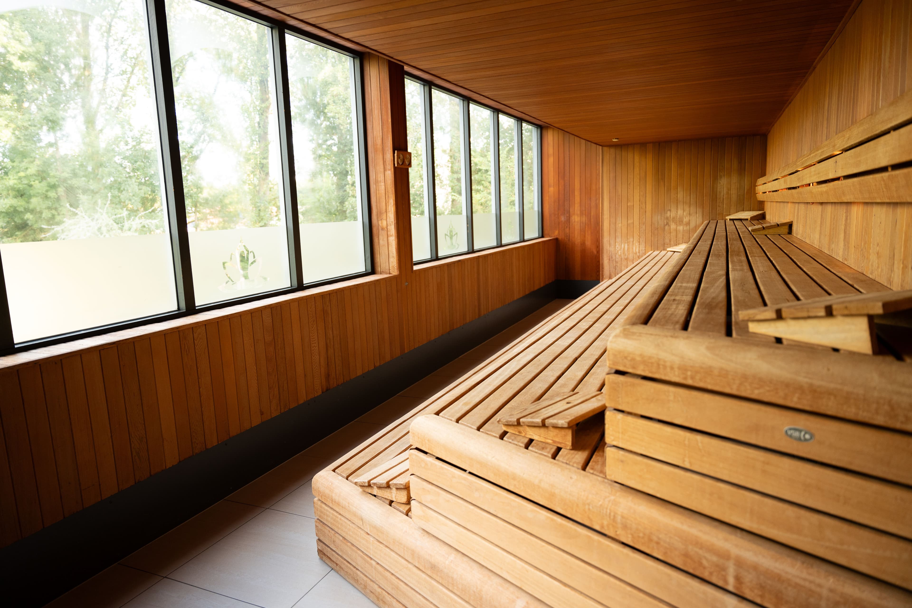 Ruime sauna met grote ramen die uitzicht bieden op de omliggende natuur
