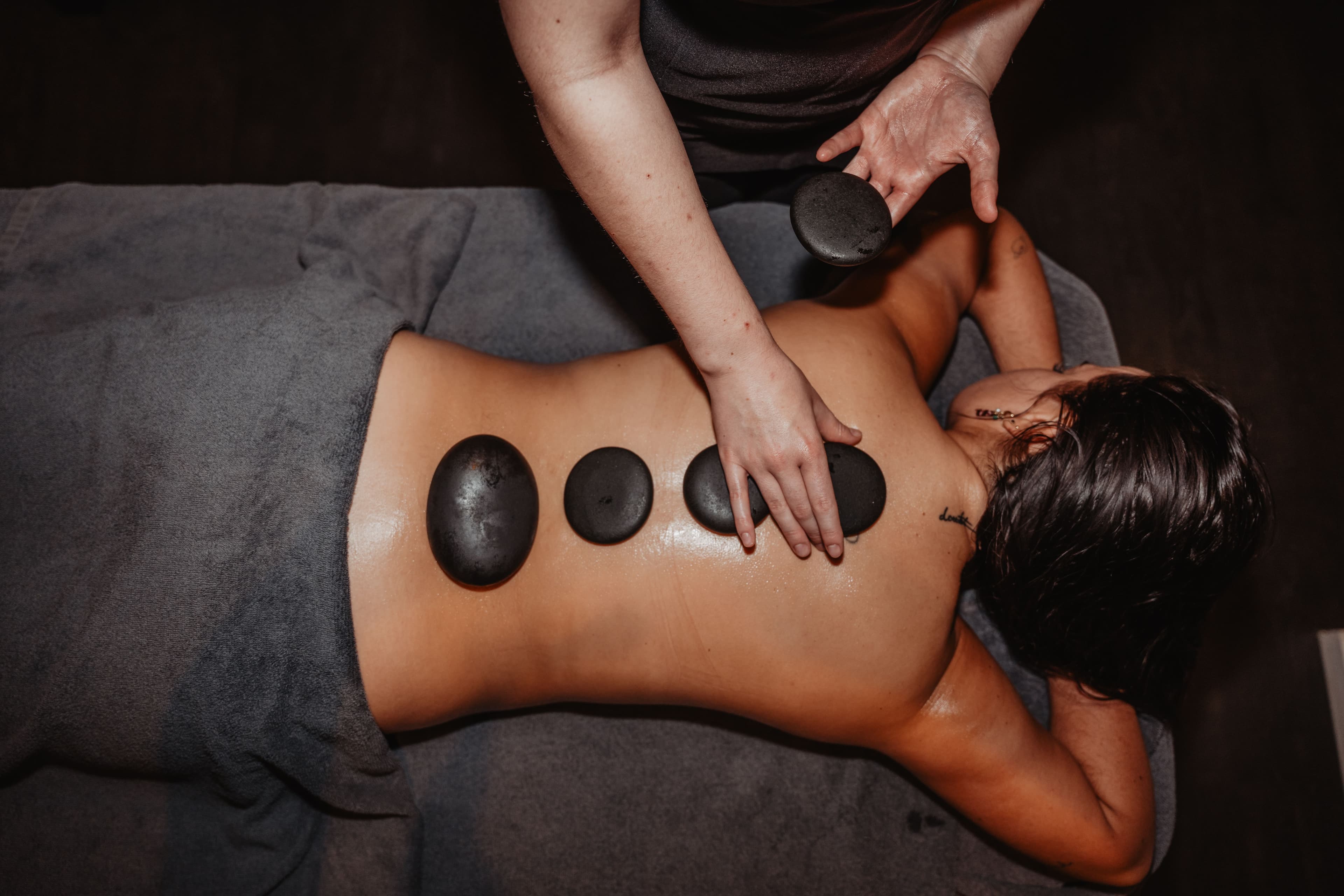 Hot stone massage op de rug voor diepere spierontspanning in de wellnessruimte