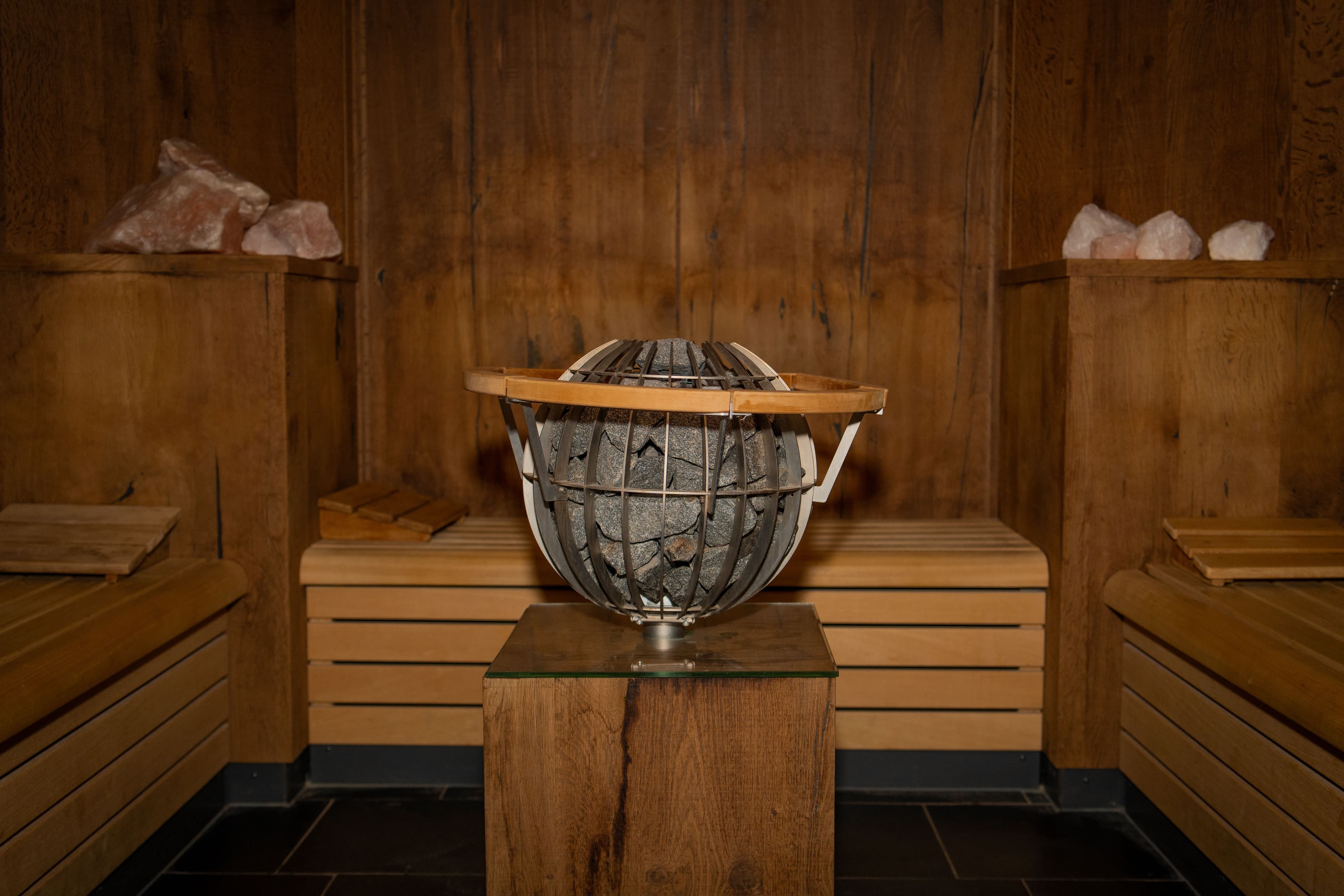 Houten sauna met centraal geplaatste oven voor optimale warmte