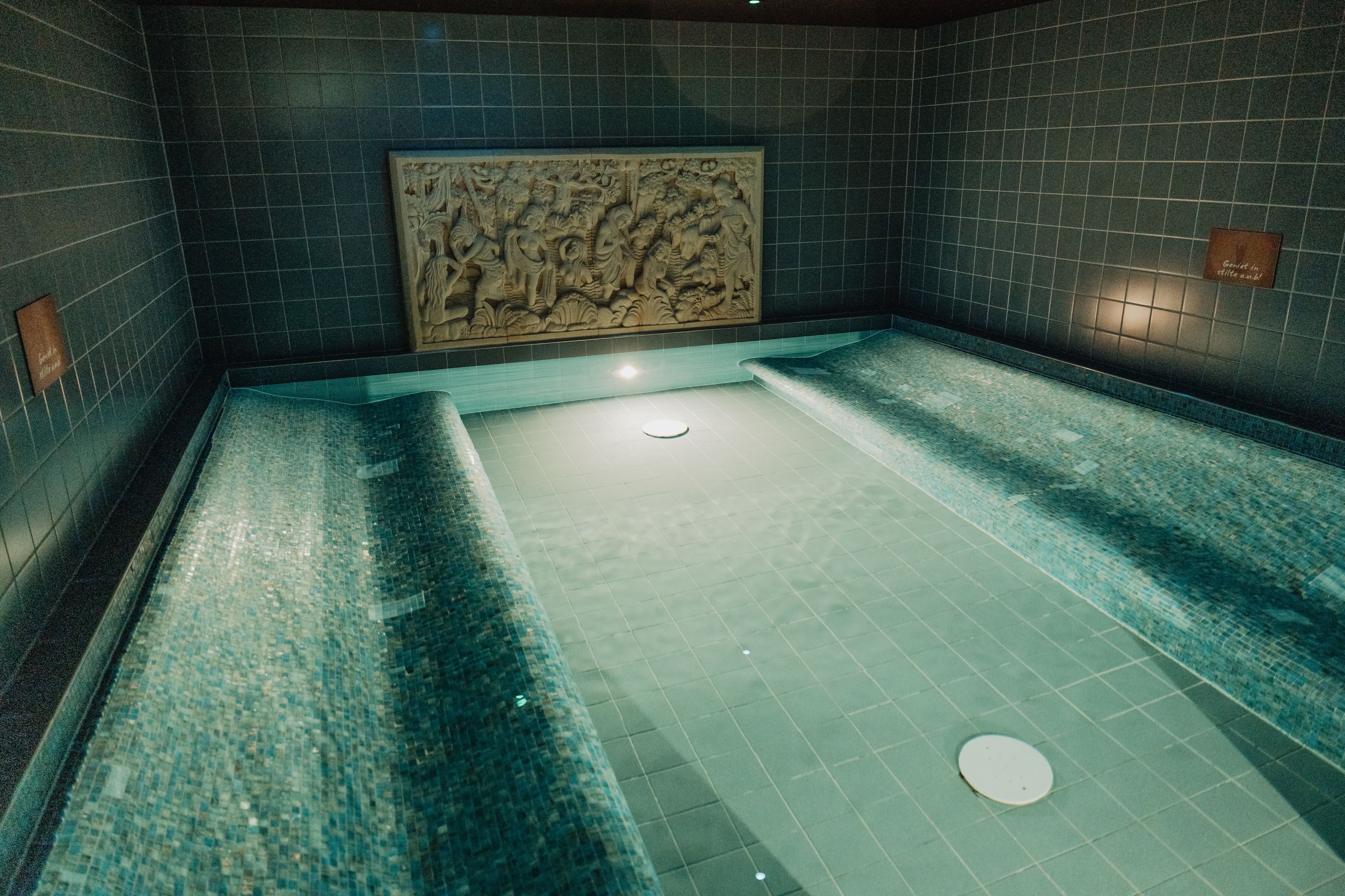 Verwarmd binnenzwembad omgeven door rustgevende verlichting en een serene sfeer in het wellnesscentrum