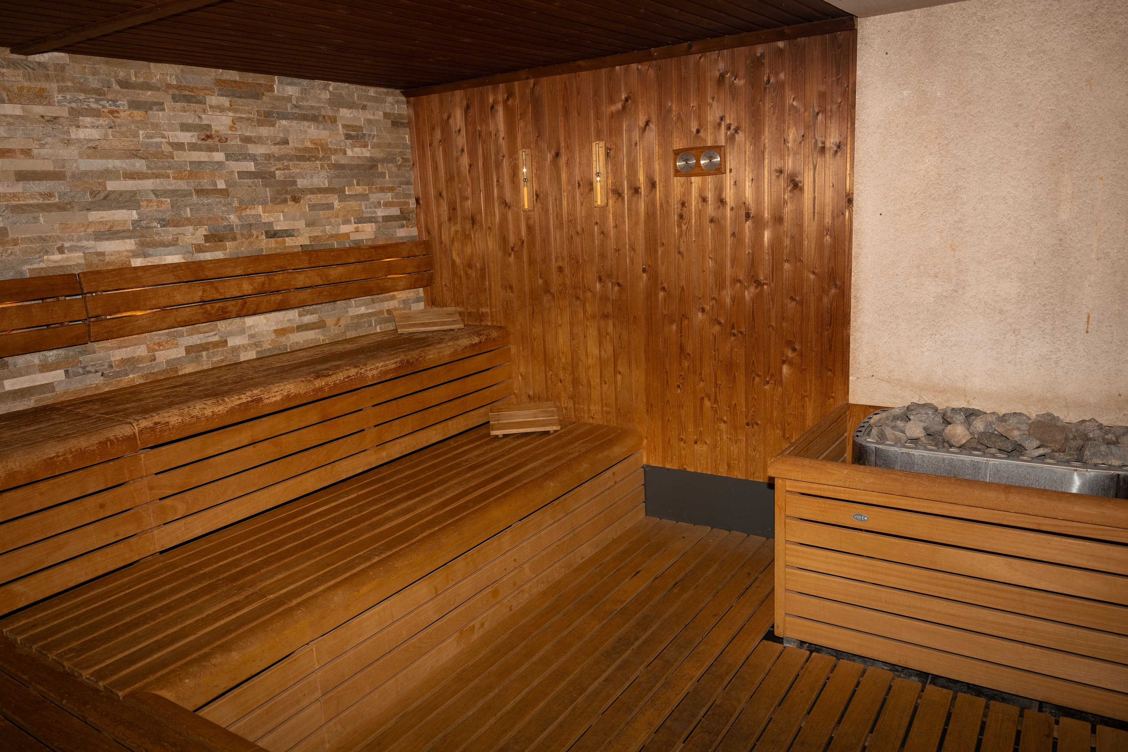 Houten sauna met bakstenen muur, ontworpen voor extra warmtebehoud