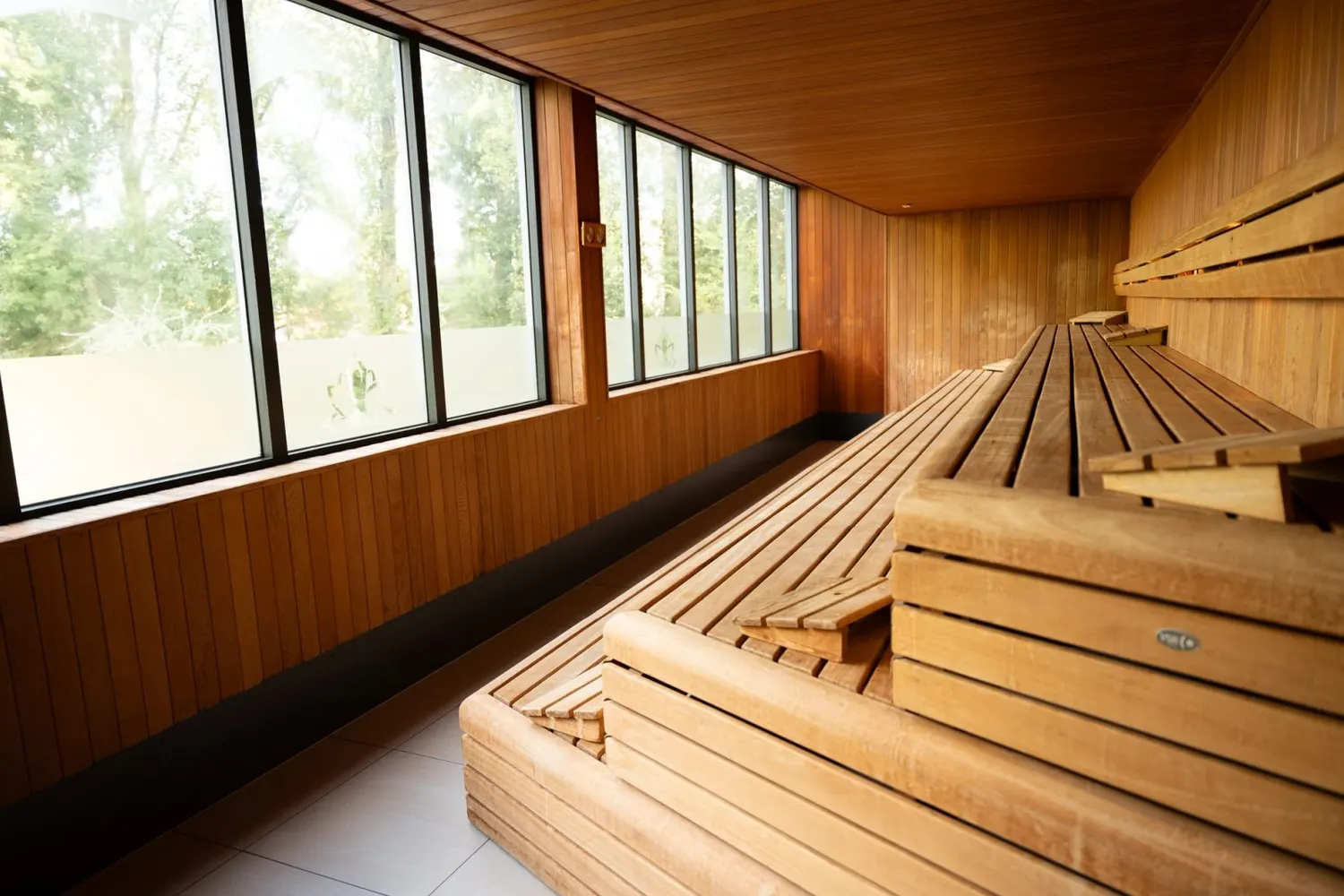 Panorama sauna with timber benches and a view of the garden